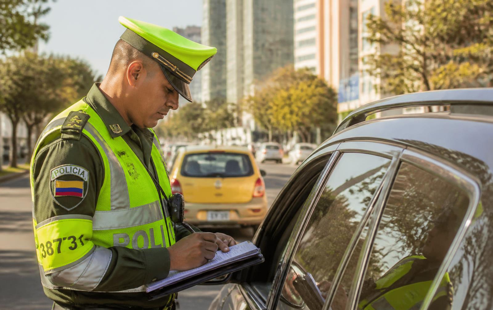 Agente de tránsito imponiendo un comparendo a un conductor en Colombia